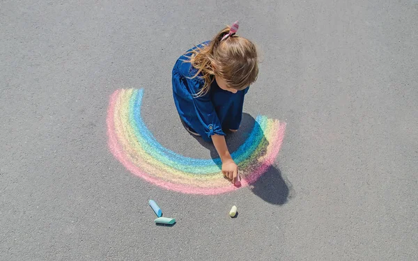 Dziecko rysuje kredą na chodniku. Skupienie selektywne. — Zdjęcie stockowe
