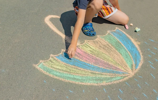 Criança desenha com giz no pavimento. Foco seletivo. — Fotografia de Stock