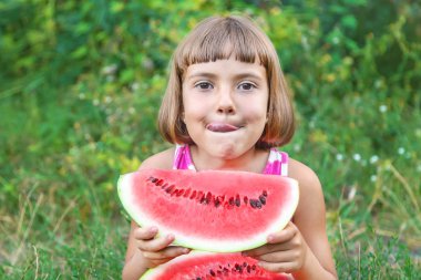 çocuk bahçede karpuz yer. Seçici odaklama.