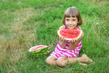çocuk bahçede karpuz yer. Seçici odaklama.