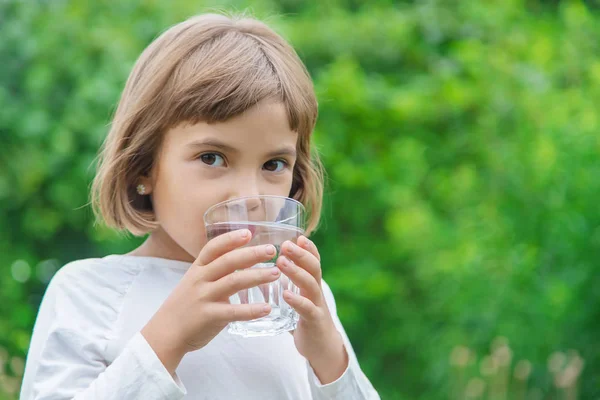 어린이는 유리잔에서 물을 마십니다. 선택적 초점. — 스톡 사진
