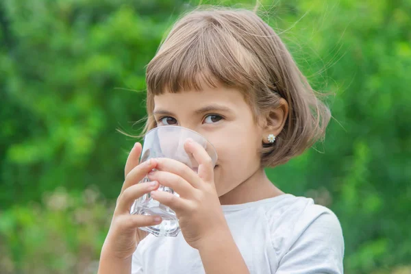 孩子从玻璃杯里喝水。选择性聚焦. — 图库照片