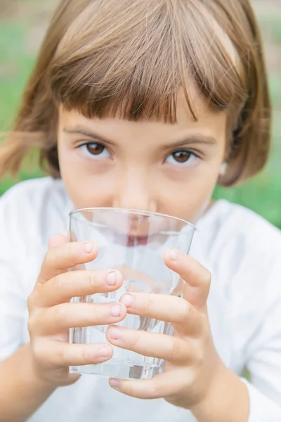 Kind drinkt water uit een glas. Selectieve focus. — Stockfoto