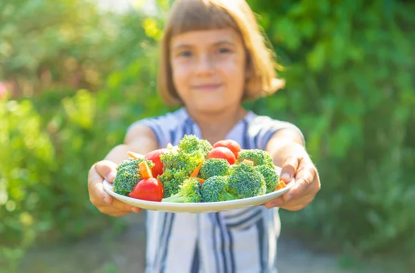 Kind eet groenten broccoli en wortelen. Selectieve focus. — Stockfoto