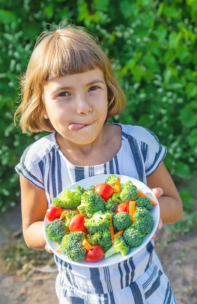 Kind eet groenten broccoli en wortelen. Selectieve focus. — Stockfoto