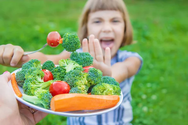 Kind isst Gemüse Brokkoli und Karotten. Selektiver Fokus. — Stockfoto