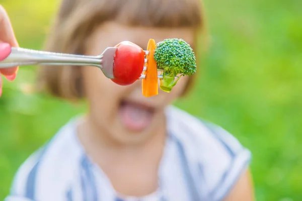 Criança come legumes brócolis e cenouras. Foco seletivo . — Fotografia de Stock