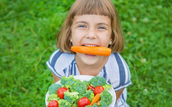아이는 야채 브로콜리와 당근을 먹는다. 선택적 초점. — 스톡 사진