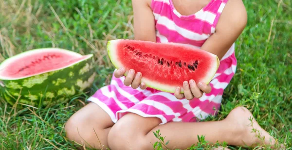 Barn äter en vattenmelon i trädgården. Selektivt fokus. — Stockfoto