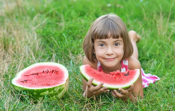 아이는 정원에서 수박을 먹는다. 선택적 초점. — 스톡 사진