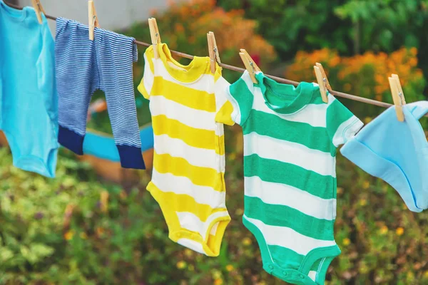 Wassen van de kleren van de baby. Linnen droogt in de frisse lucht. Selectieve focus. — Stockfoto