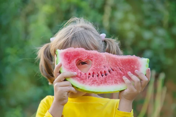 Kind eet een watermeloen in de tuin. Selectieve focus. — Stockfoto