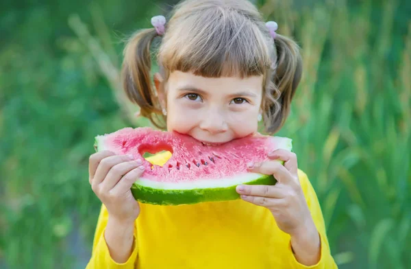 아이는 정원에서 수박을 먹는다. 선택적 초점. — 스톡 사진