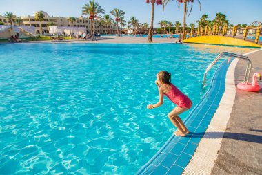 Çocuk yüzüyor ve havuza dalıyor. Seçici odak.