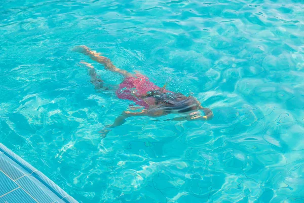 Het kind zwemt en duikt in het zwembad. Selectieve focus. — Stockfoto