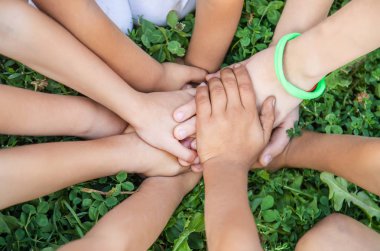 çocukların elleri birlikte çim bir arka plan üzerinde. Seçici odaklama.