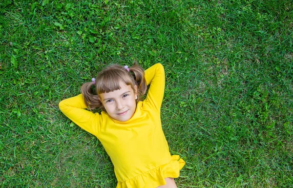 这孩子躺在草地上。选择性聚焦. — 图库照片