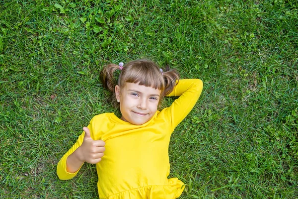 Anak itu terbaring di rumput. Fokus selektif . — Stok Foto