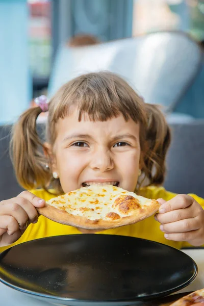 Dziecko zjada pizzę z sera. Selektywna koncentracja. — Zdjęcie stockowe