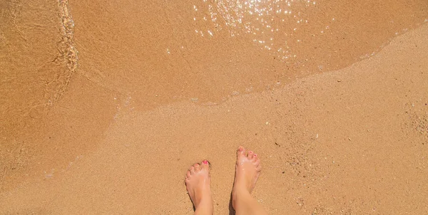 一个女孩在海边的腿。选择性聚焦. — 图库照片