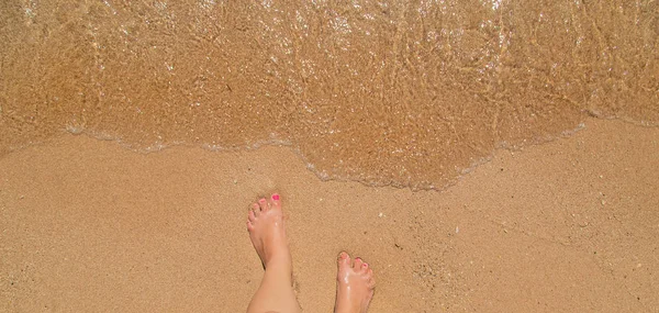 一个女孩在海边的腿。选择性聚焦. — 图库照片