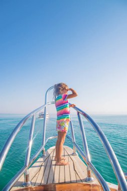 Yat üstünde denize açılan bir çocuk. Seçici odak.