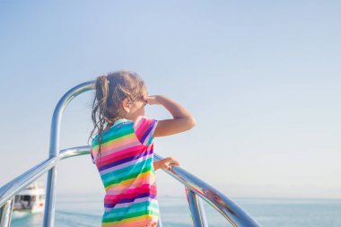 Yat üstünde denize açılan bir çocuk. Seçici odak.