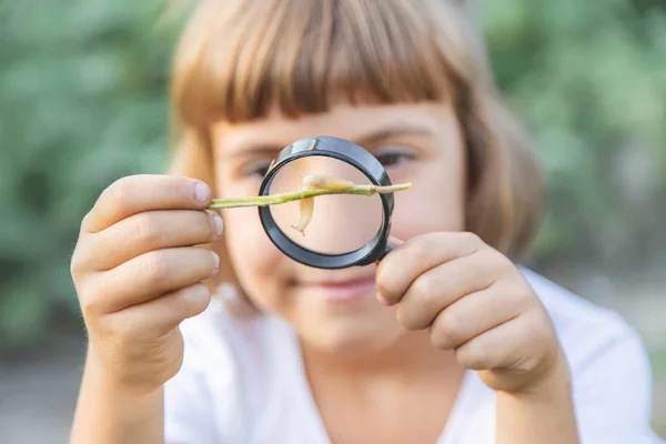 Bambino con una lente d'ingrandimento in mano. Focus selettivo . — Foto Stock