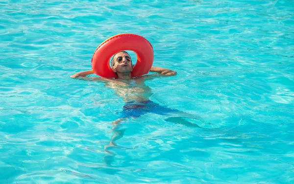 Man swims in a pool with a circle. Selective focus. — Stock Photo, Image