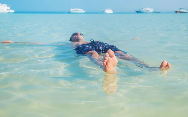 Un homme nage dans la mer couché sur le dos. Concentration sélective . — Photo