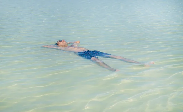 Schwimmt ein Mann auf dem Rücken liegend im Meer. Selektiver Fokus. — Stockfoto