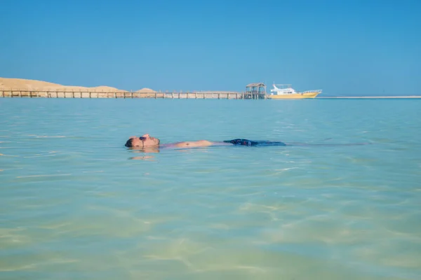 Schwimmt ein Mann auf dem Rücken liegend im Meer. Selektiver Fokus. — Stockfoto