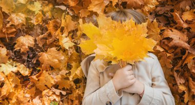 Sonbahar yapraklarıyla parktaki çocuklar. Seçici odak.