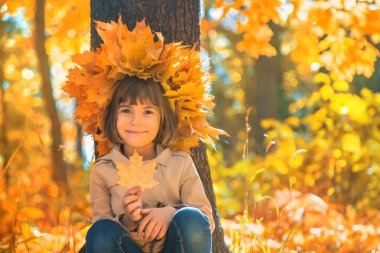 Sonbahar yapraklarıyla parktaki çocuklar. Seçici odak.