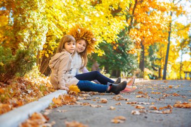 Sonbahar yapraklarıyla parktaki çocuklar. Seçici odak.