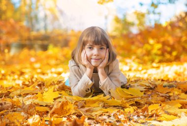 Sonbahar yapraklarıyla parktaki çocuklar. Seçici odak.