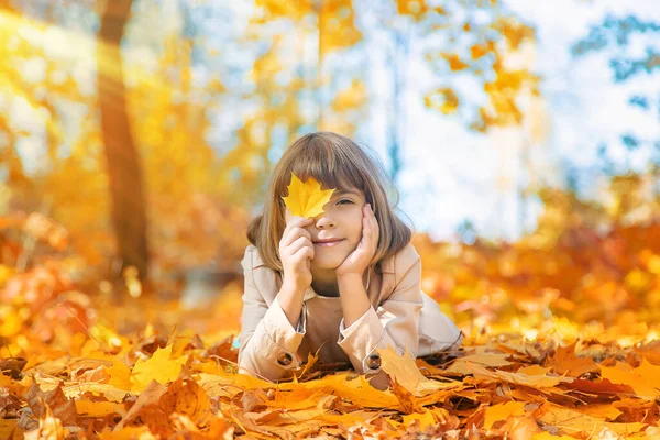 Enfants dans le parc avec des feuilles d'automne. Concentration sélective. — Photo