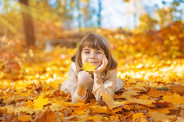 Enfants dans le parc avec des feuilles d'automne. Concentration sélective. — Photo