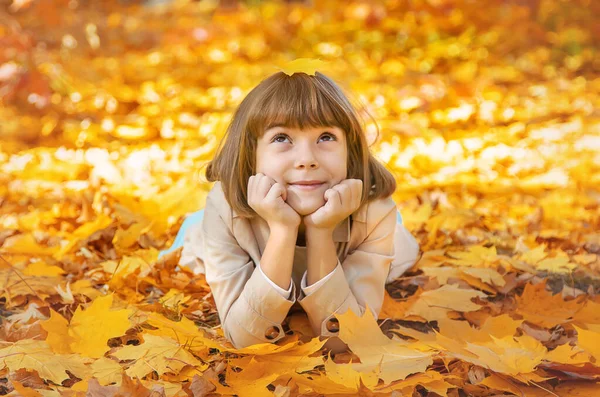 Enfants dans le parc avec des feuilles d'automne. Concentration sélective. — Photo