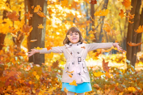 Enfants dans le parc avec des feuilles d'automne. Concentration sélective. — Photo