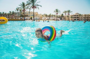 Çocuk yüzüyor ve havuza dalıyor. Seçici odak.