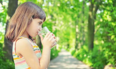 Bir çocuk doğadaki bir bardaktan su içer. Seçici odaklanma. İç..