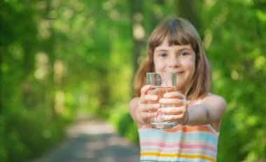 Bir çocuk doğadaki bir bardaktan su içer. Seçici odaklanma. İç..