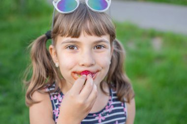 Çocuk yaz aylarında çilek yer. Seçici odaklanma. insanlar.