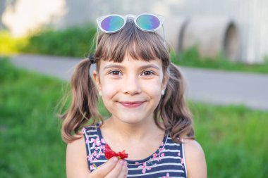 Çocuk yaz aylarında çilek yer. Seçici odaklanma. insanlar.