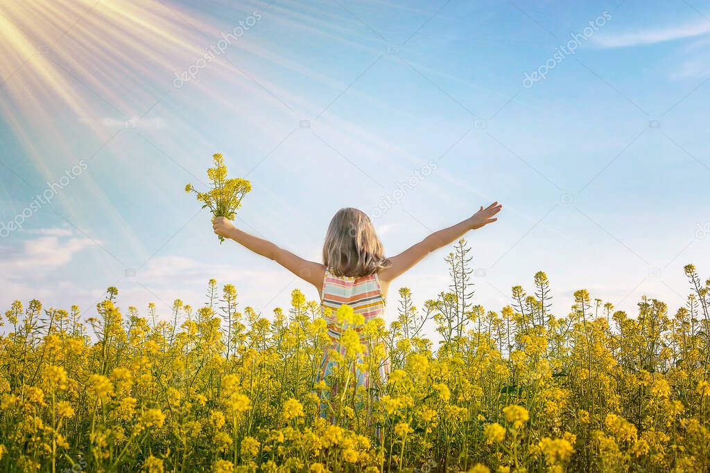 A child in a yellow field, mustard blooms. Selective focus. nature.