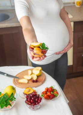 Hamile bir kadın meyve yer. Seçici odaklanma. yiyecek.