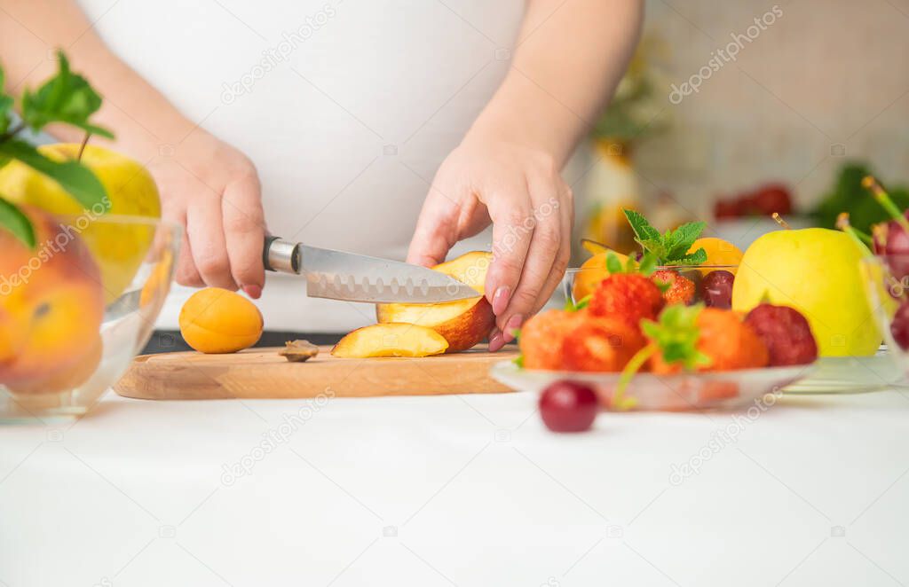 A pregnant woman eats fruit. Selective focus. food.