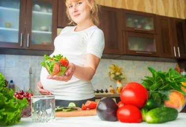 Hamile bir kadın sebze ve meyve yer. Seçici odaklanma. Yiyecek..