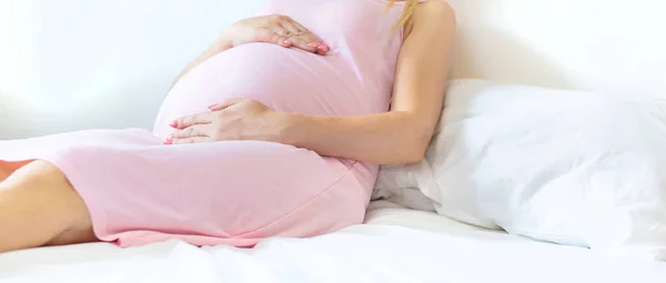 一个躺在床上的孕妇抱着她的胃 有选择的重点 — 图库照片